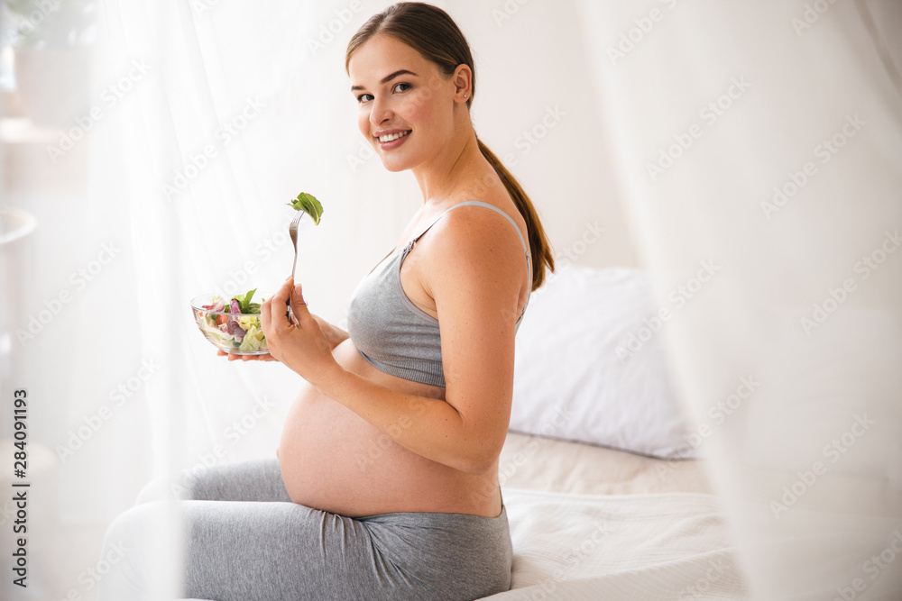 Smiling pregnant lady eating healthy food at home Smiling pregnant lady eating healthy food at home