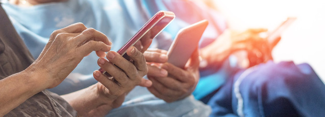 Happy elderly senior people society lifestyle technology concept. Ageing Asia women using tablet smartphone or mobile phone share social media together in wellbeing county home.