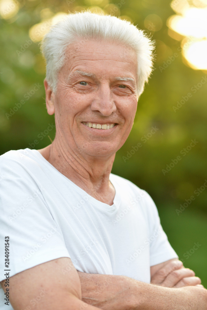 portrait of smiling senior man in park portrait of smiling senior man in park