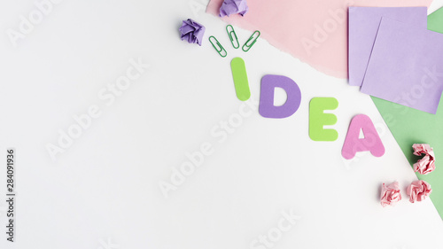 Colorful paper cutout of idea text letter and paperclip with crumpled paper © Freepik