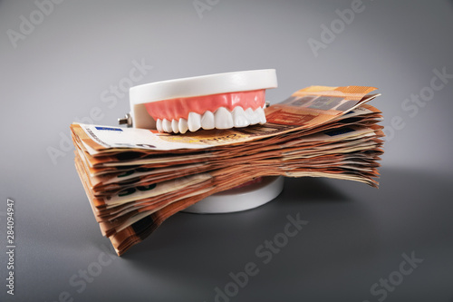 greediness concept - teeth model eating euro money bills photo