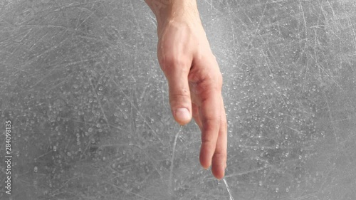 Water flows through theman's hand on grey background. Time as water flows through the fingers. Hand close-up. photo