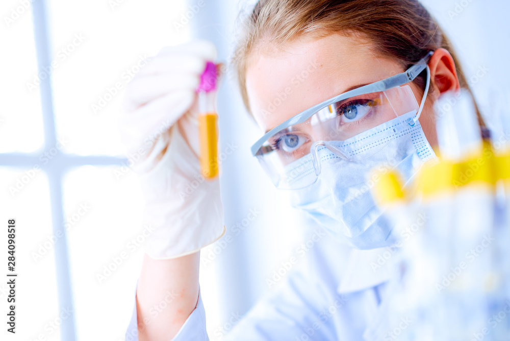 Woman holding test tube. Chemist is analyzing sample in laboratory room Woman holding test tube. Chemist is analyzing sample in laboratory room