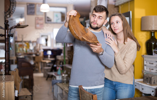 Girl with boyfriend buying original wooden plate