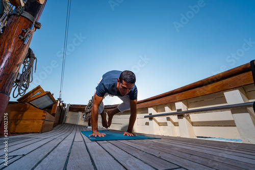 Man practicing Yoga on a sailing yacht