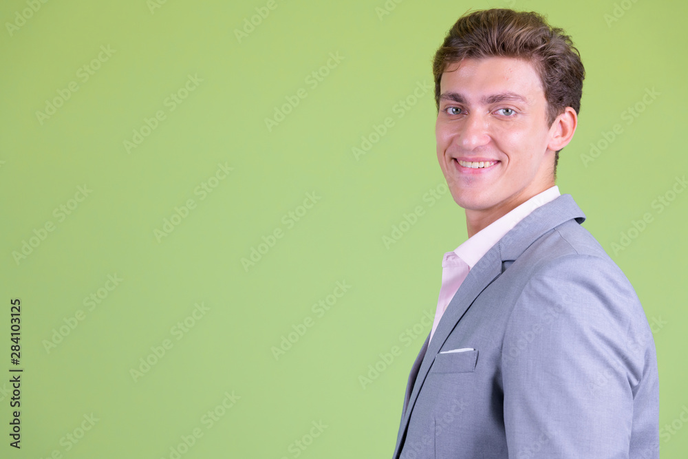Closeup profile view of happy young handsome businessman smiling Closeup profile view of happy young handsome businessman smiling