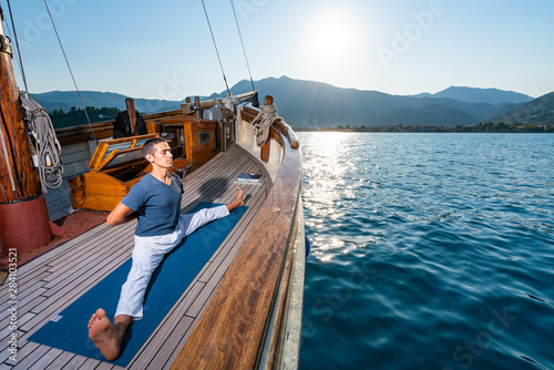 Man practicing Yoga on a sailing yacht © Netfalls
