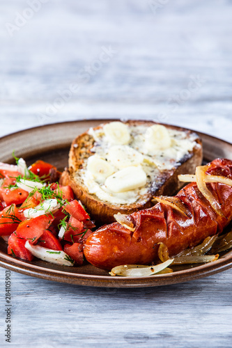 Grilled sausage, toast and vegetable salad