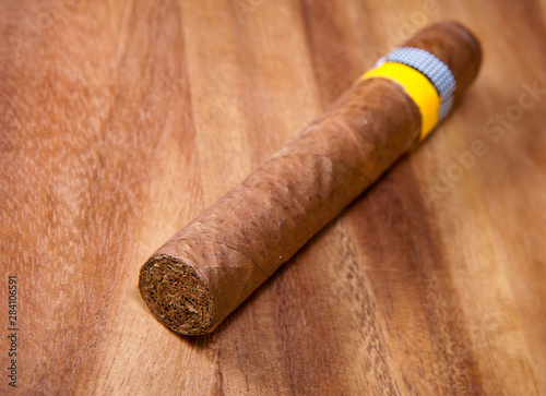 rolled cigar from a tobacco leaf on a wooden background, Small depth of sharpness..