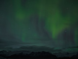 Nordlichter über den verschneiten Bergen in Island