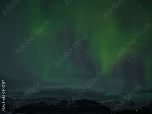 Nordlichter über den verschneiten Bergen in Island © TravelPOIs