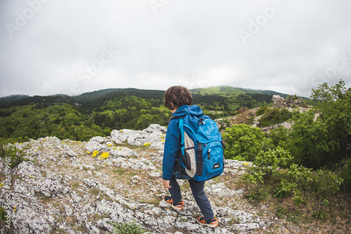 The boy walks along a mountain path. © zhukovvvlad