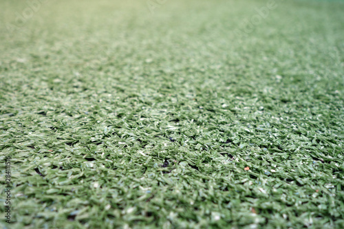 Artificial green color grass with blur effect.