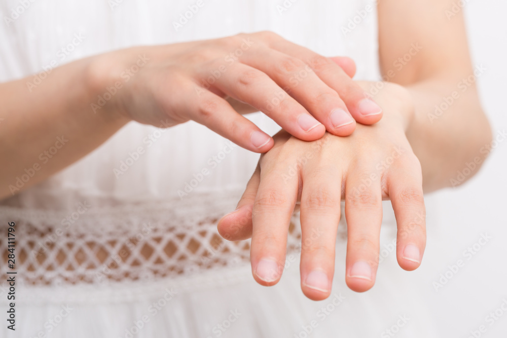 Female applying cream to her hands Female applying cream to her hands