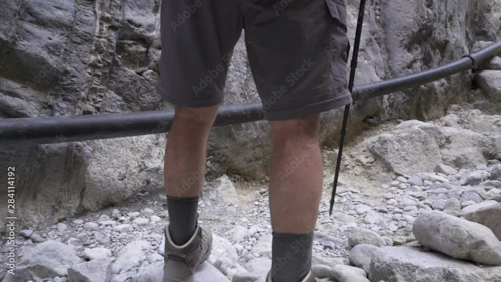 A tourist walks along the gorge with trekking poles. Slow motion A tourist walks along the gorge with trekking poles. Slow motion