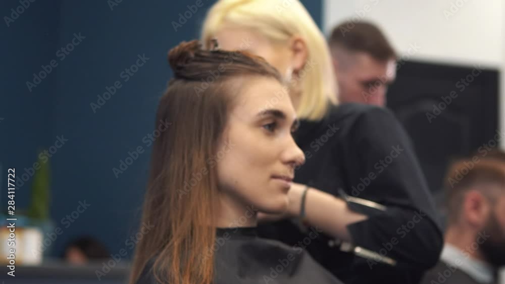 Portrait of happy woman at the hair salon. Professional hair styling concept. Hairdresser drying girl long hair using hairdryer and brush. Drying With Blow Dryer Portrait of happy woman at the hair salon. Professional hair styling concept. Hairdresser drying girl long hair using hairdryer and brush. Drying With Blow Dryer