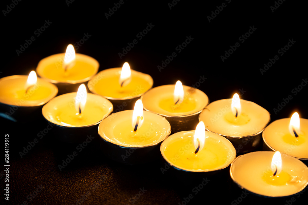 Candles burning in the dark. Holiday, Romance or Religion concept. Candles on a wooden background Candles burning in the dark. Holiday, Romance or Religion concept. Candles on a wooden background