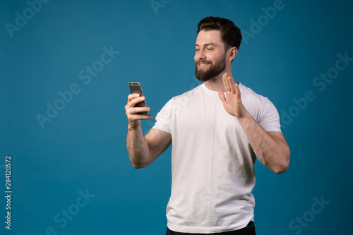 Handsome man use phone for video chatting. Video call. Concept away from friends.