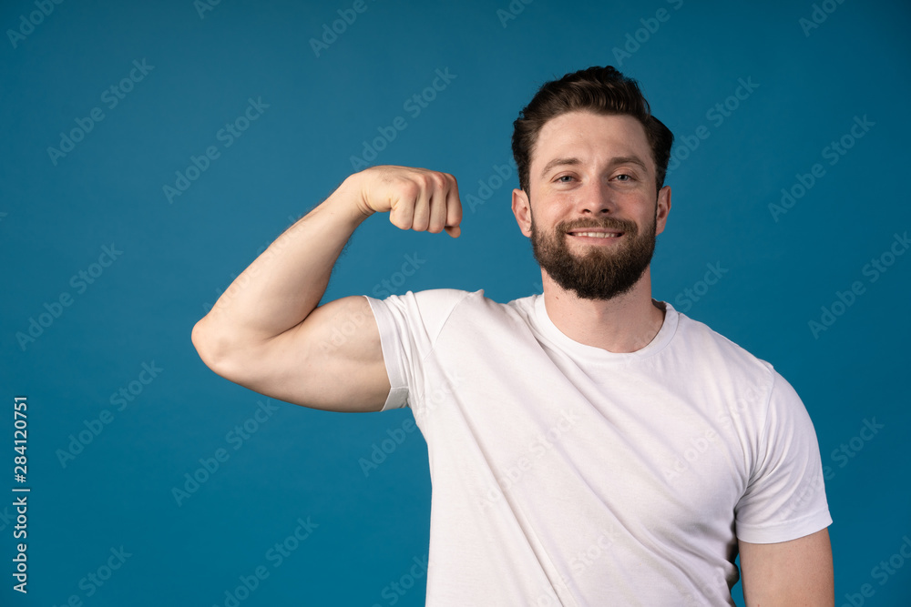 A strong athletic young man model showing biceps. smiling man . Portrait of a handsome man.