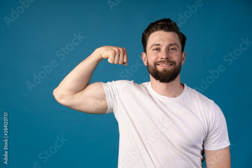 A strong athletic young man model showing biceps. smiling man . Portrait of a handsome man.