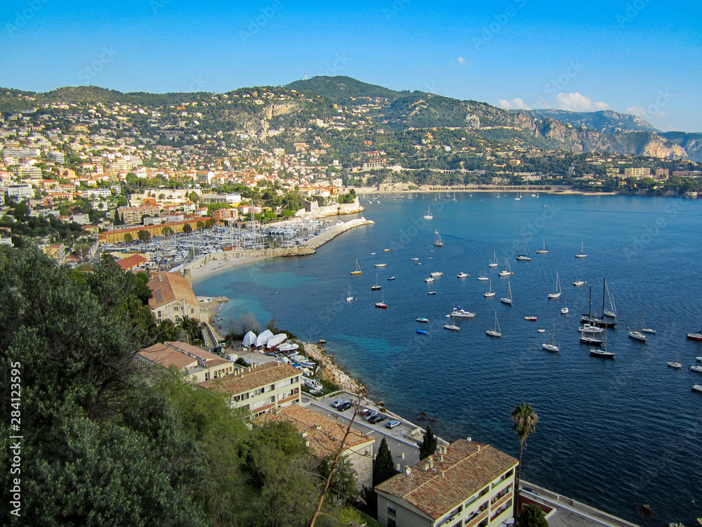 An overlook in the south of France with sailboats, houses on a hillside and a french city on a beautiful fall day.