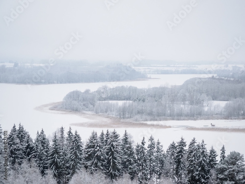 Winter view of the lake and trees in Lithuania. Panorama of landscape in the fog.