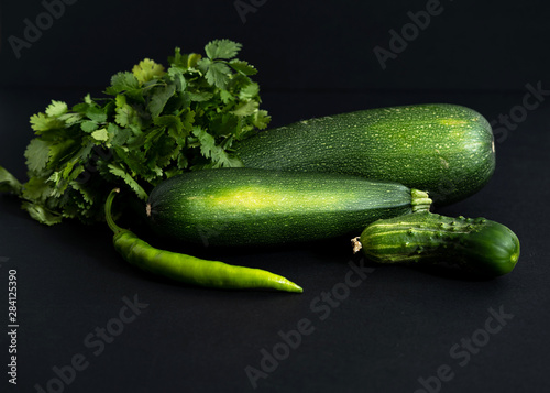 whole green vegetables on a black background, close-up top view, copy space, horizontal frame