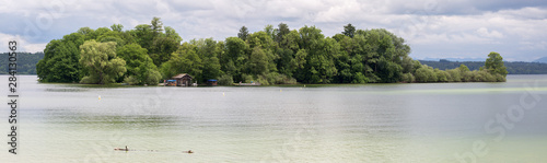 FELDAFING, BAVARIA / GERMANY - June 16, 2019: Panorama view of the Roseninsel (rose island) at Lake Starnberg. Famous rose garden. The pile dwellings around the island are an Unesco World Heritage.