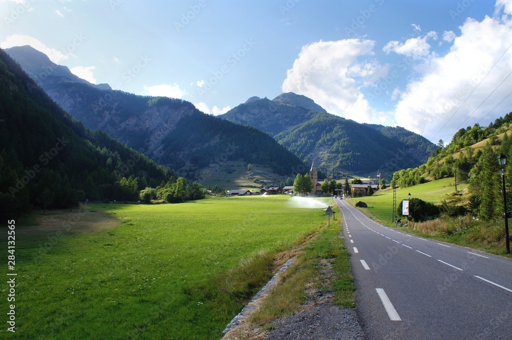 Naklejka premium Mountain pastures in the national parc Queras in French alps, and the village of Arvieux, known to be an historical refuge during religious persecutions