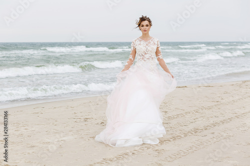 Portrait of a beautiful bride on the beach in windy weather