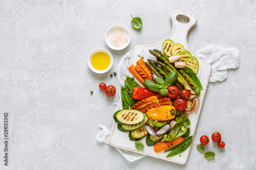 Grilled assorted vegetables on a kitchen board, top down view, space for a text © Fattyplace