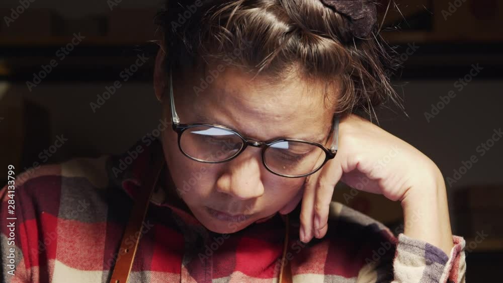 Asian women are designing ceramic cookware at night, Small business concept in the household, Asian women wearing glasses are working stressfully during the night. Asian women are designing ceramic cookware at night, Small business concept in the household, Asian women wearing glasses are working stressfully during the night.