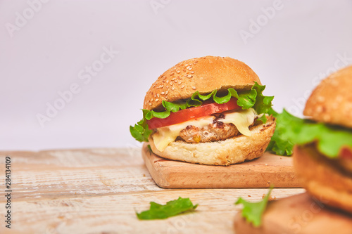 Craft beef burger on wooden table on light background. Street food, fast food. Homemade juicy burgers with cheese and on the wooden table. Copy space.