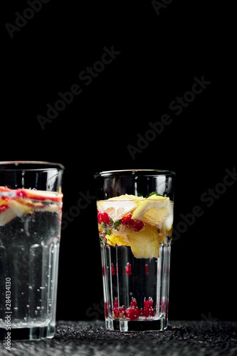 Variety of Detox infused water with kiwi, apple, lavender, ginger, lemon, mint on black background. Refreshing summer homemade cocktail. Diet. Healthy drink. Copy space.