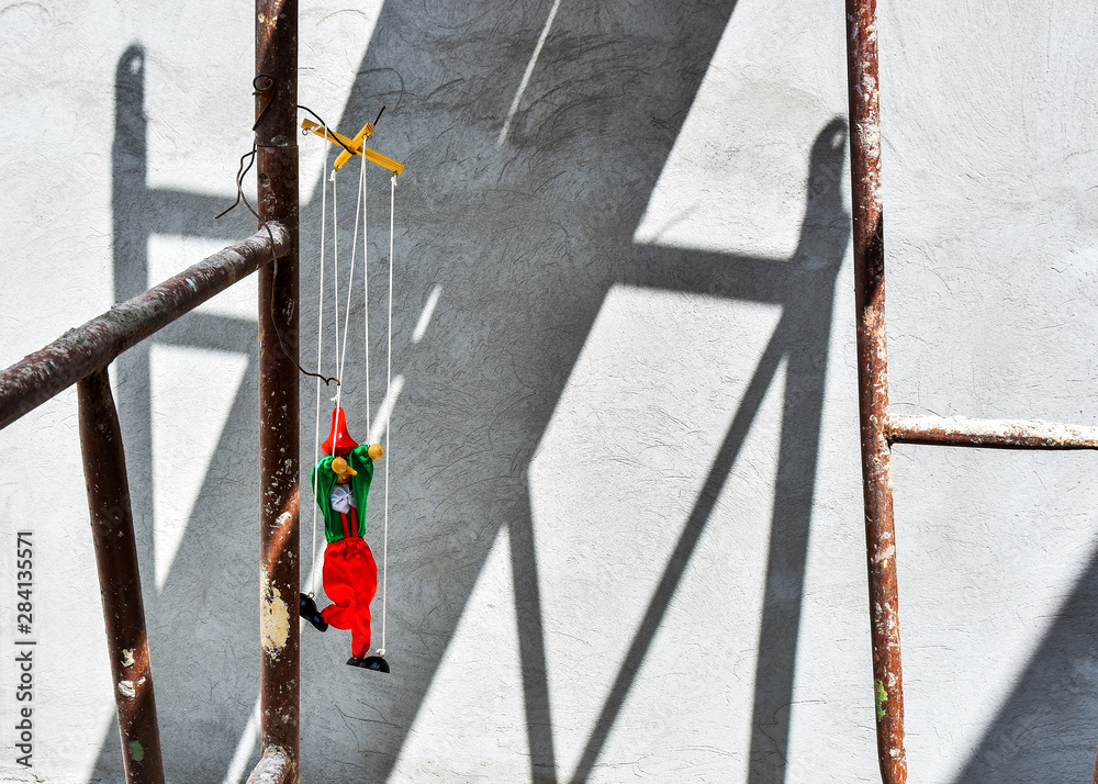 Old wooden pinocchio puppett . Creative background with a wall in