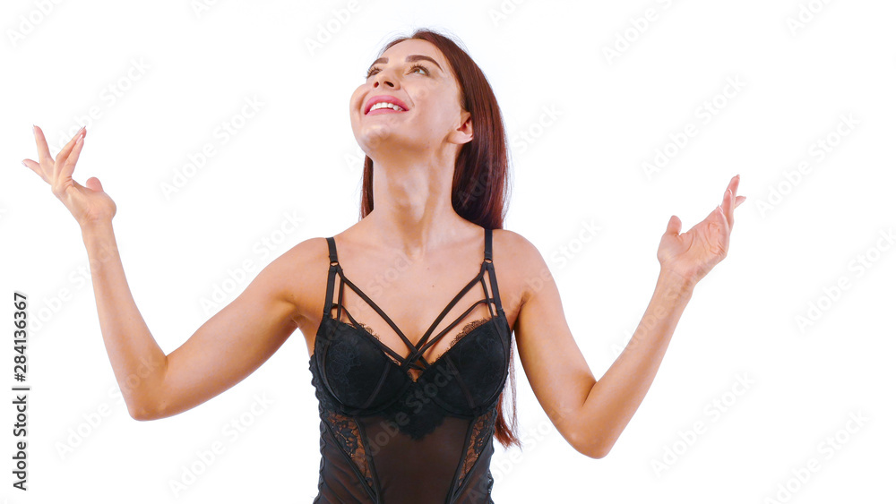 Joyful girl in lacy lingerie looks up waving her arms. Joyful girl in lacy lingerie looks up waving her arms.
