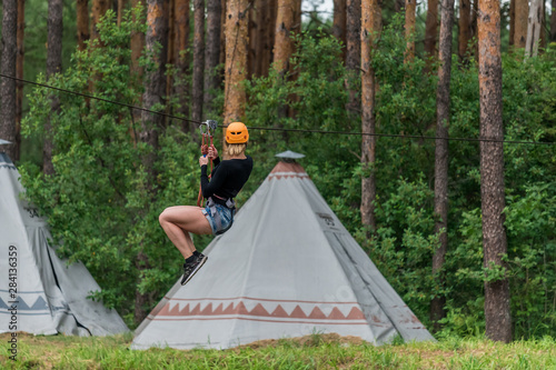 Girl pulls out on a bungee against the background of the forest Fototapete
