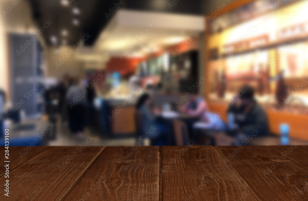 Wooden perspective table in front of abstract blurred background of cafe or restaurant Wooden perspective table in front of abstract blurred background of cafe or restaurant