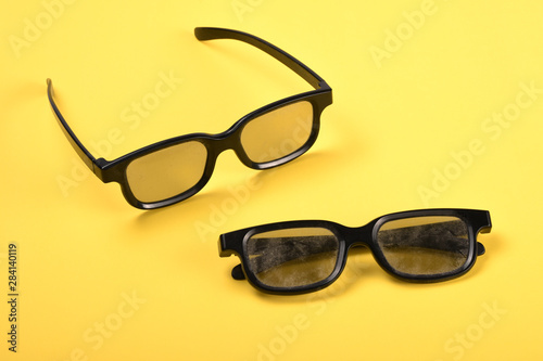Dusty eyeglasses on yellow background