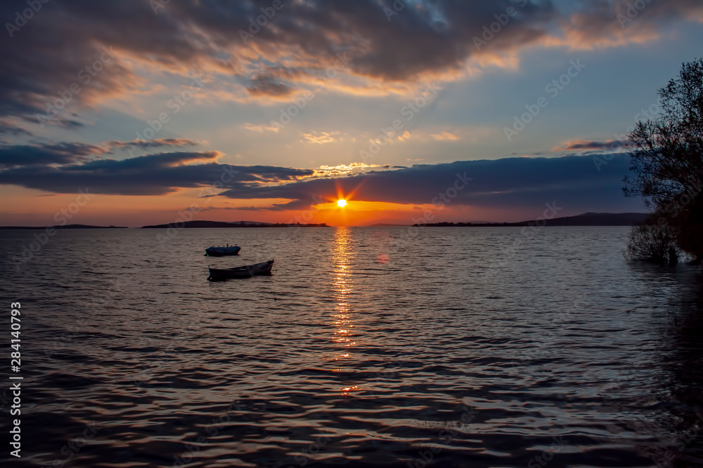 Fototapeta premium Blue fishing boat at sunset on the Black Sea