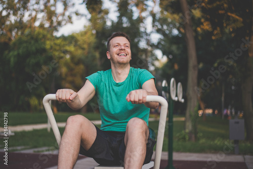 A young man training at the outdoor gym