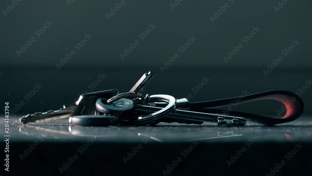 Bunch of keys falls down on the table, slow motion shot