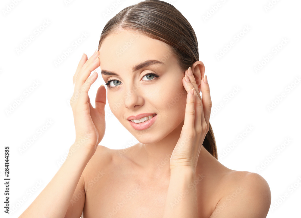 Beautiful woman massaging her face against white background Beautiful woman massaging her face against white background