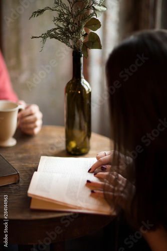 Young woman in a cafe with a book