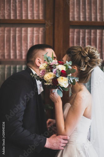 bride and groom with wedding bouquet of flowers