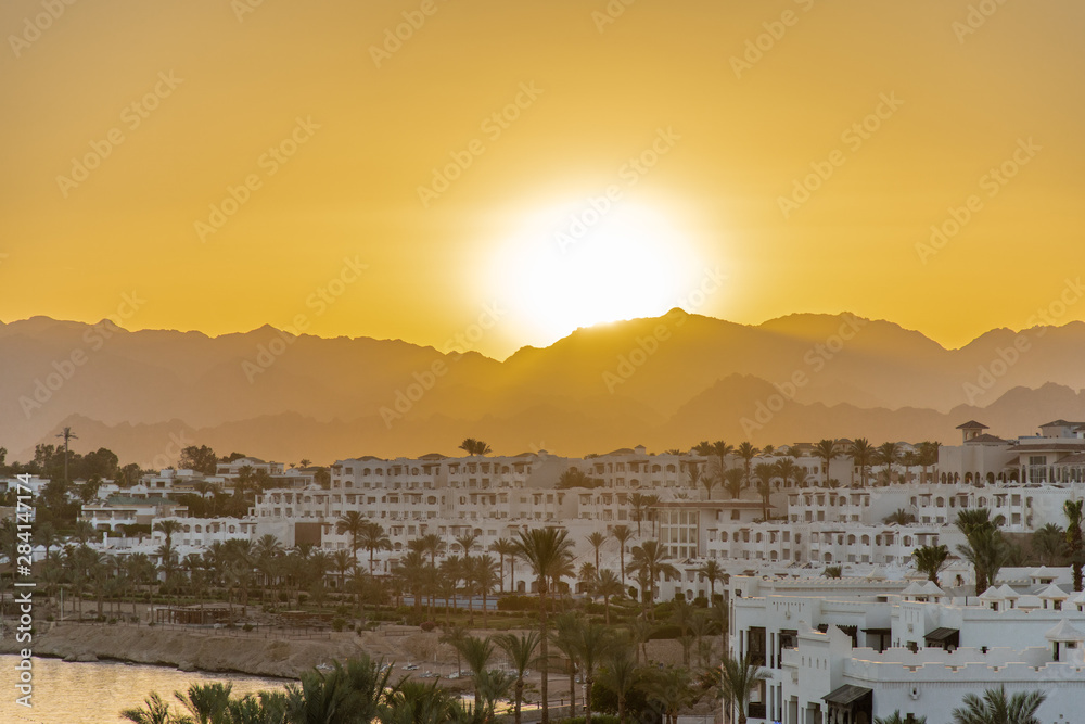 Sharm el Sheikh, Egypt - May, 2019: Panorama of the beach with umbrellas at the reef on sunset, Sharm el Sheikh, Egypt