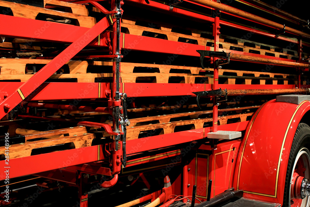 Fototapeta premium stack of wood ladders on vintage fire truck