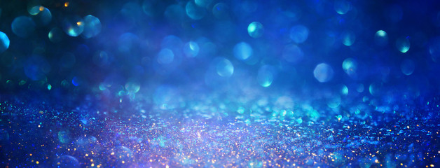 blackground of abstract glitter lights. blue, gold and black. de focused
