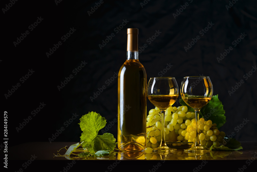 Fototapeta premium The composition of bottle 2 glass of white wine and fresh grapes