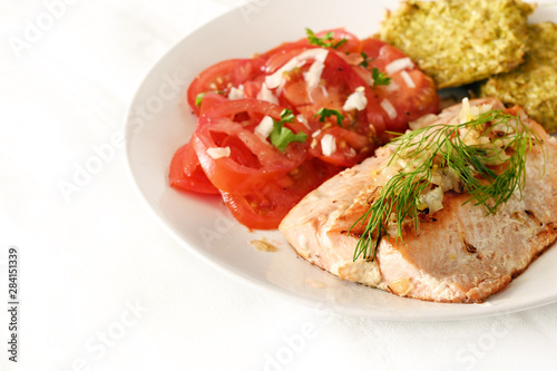 fried salmon with tomatoes, low carb diet food on a white table with copy space, selected focus, narrow depth of field